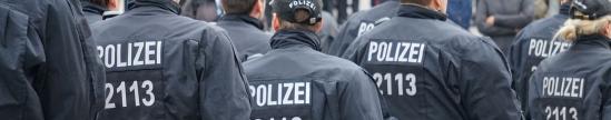 Viele Polizisten in Kampfmontur, aber ohne Helm auf dem Kopf