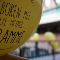 "Geboren mit der Hilfe einer Hebamme" - mit diesem Slogan solidarisierten sich auch in Norderstedt Hunderte mit dem bedrängten Berufsstand (Foto: Infoarchiv). Gelber Luftballon, Aufschrift: Geboren mit der Hilfe einer Hebamme.
