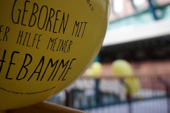 "Geboren mit der Hilfe einer Hebamme" - mit diesem Slogan solidarisierten sich auch in Norderstedt Hunderte mit dem bedrängten Berufsstand (Foto: Infoarchiv). Gelber Luftballon, Aufschrift: Geboren mit der Hilfe einer Hebamme.
