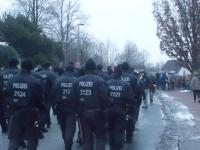 Polizeikräfte in Kampfmontur, hinter dem Demonstrationszug