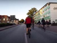 Vom Kreisel aus ging´s Richtung Glashütte und dort wieder zurück in Richtung Hamburg (Screenshot youtube-Video). Radfahrer auf der Straße, am Rande das weiß-hellblaue "Quast-Quartier"