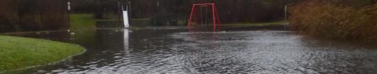 Land unter im Heidberg-Park hinterm Norderstedter-Rathaus (Foto: Infoarchiv). Eine Schaukel, eine Rutsche und ganz viel Wasser ...