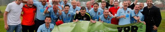Die Sieger des IGLFA-Cups 2015 mit Organisationschef Alexander von Beyme (li.) und Ex-Nationalspieler Thomas Hitzlsperger (re.), Foto: philippszyza.com Jubelnde Sportler in hellblauen Trikot mit grünem Transparent "Vorspiel"